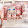 Lot de deux bouteilles d’eau Evian miniature en résine, accessoire réaliste pour maison de poupée échelle 1:12. En situation
