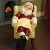 Figurine Père Noël en résine endormi sur fauteuil.