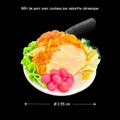 Rôti de porc aux raisins miniature avec couteau sur assiette en céramique