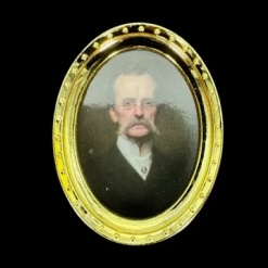 Cadre photo miniature doré avec portrait homme moustachu – vue fond noir