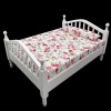 Lit miniature en bois blanc avec matelas fleuri