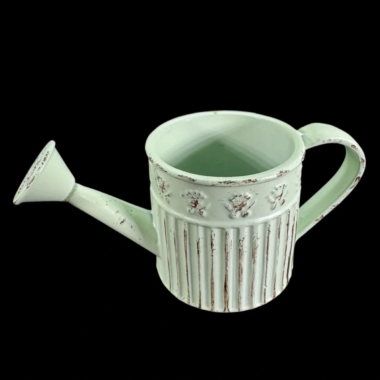 Arrosoir miniature vert pâle en métal vieilli présenté sur fond noir
