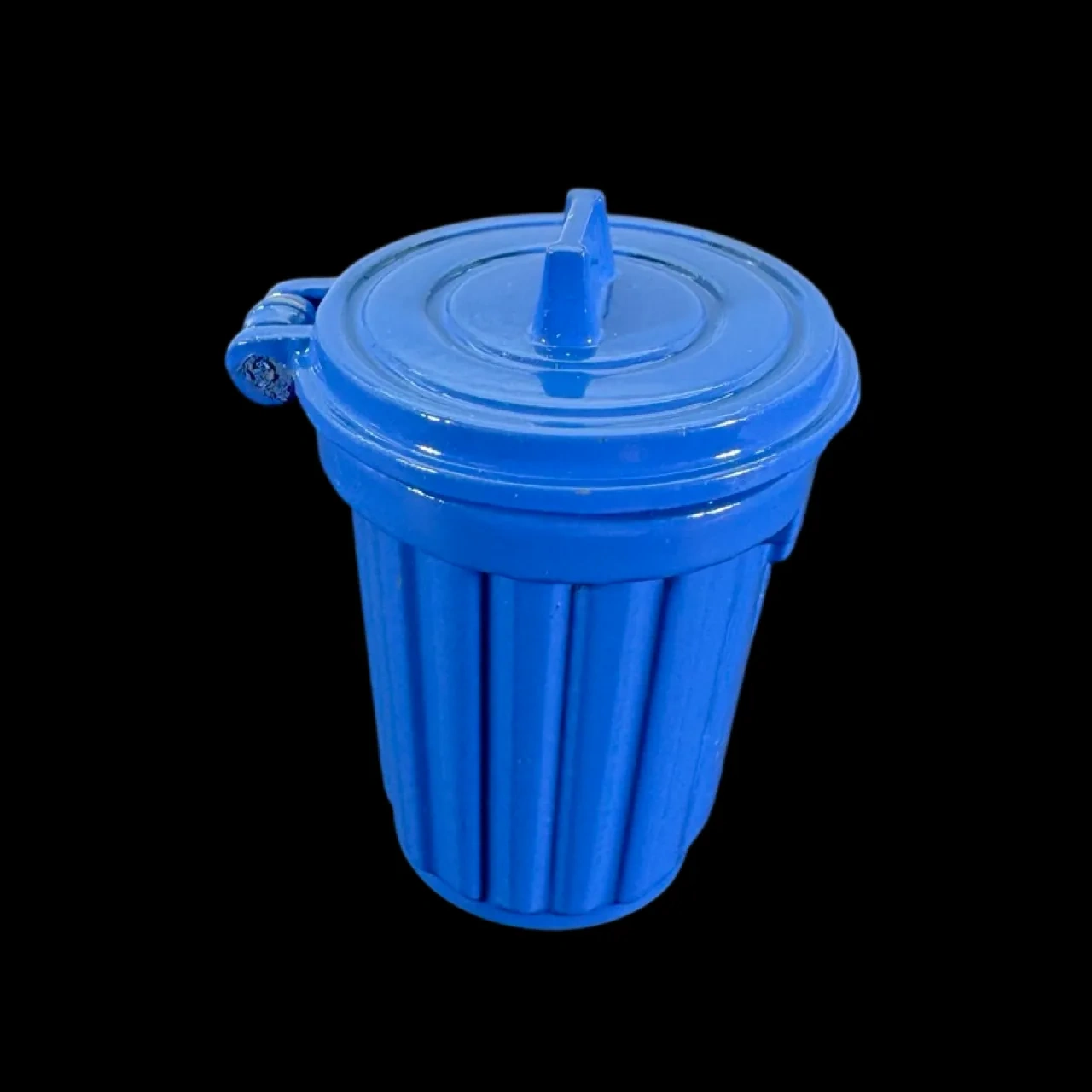 Poubelle miniature bleue en métal avec couvercle sur fond noir