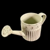 Arrosoir miniature crème en métal vieilli vu de dessus sur fond noir