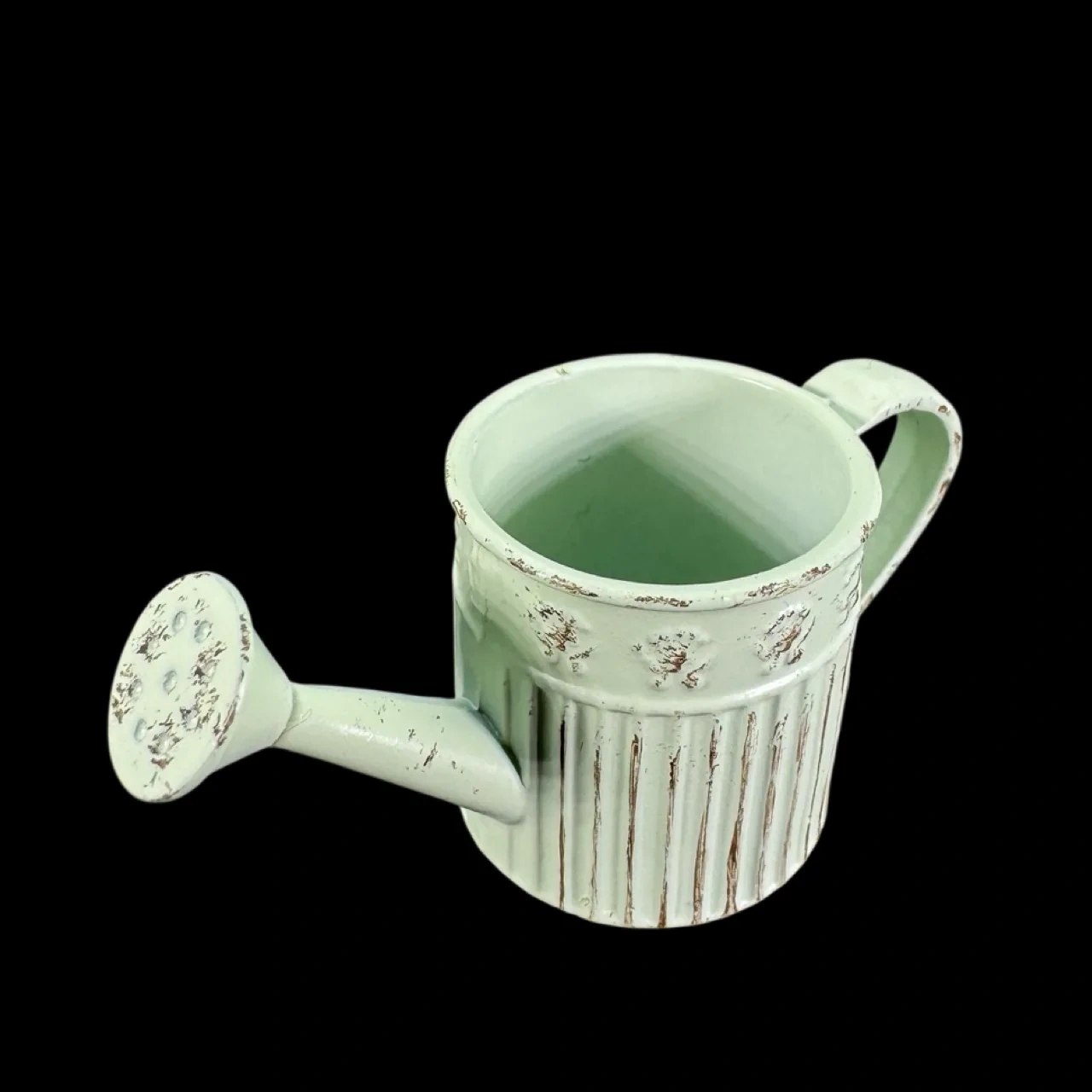Arrosoir miniature vert pâle en métal vieilli vu de dessus sur fond noir