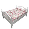 Lit miniature blanc avec matelas fleuri sur fond blanc