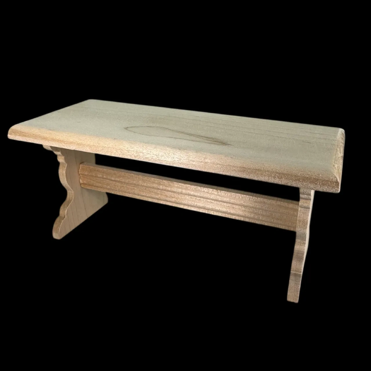 Banc miniature en bois brut vu de côté sur fond noir