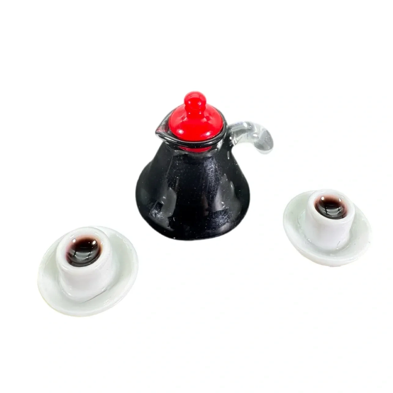 Cafetière miniature noire avec bouchon rouge et deux tasses de café