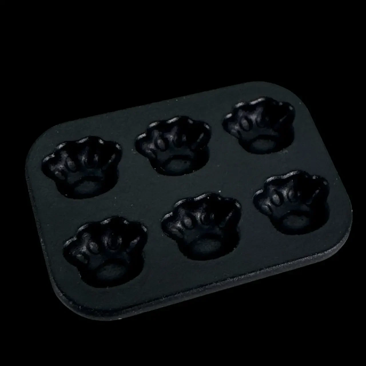 Moule à gâteaux miniature noir avec six empreintes en forme de pattes d’ours