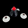 Cafetière miniature noire avec deux tasses de café sur fond noir