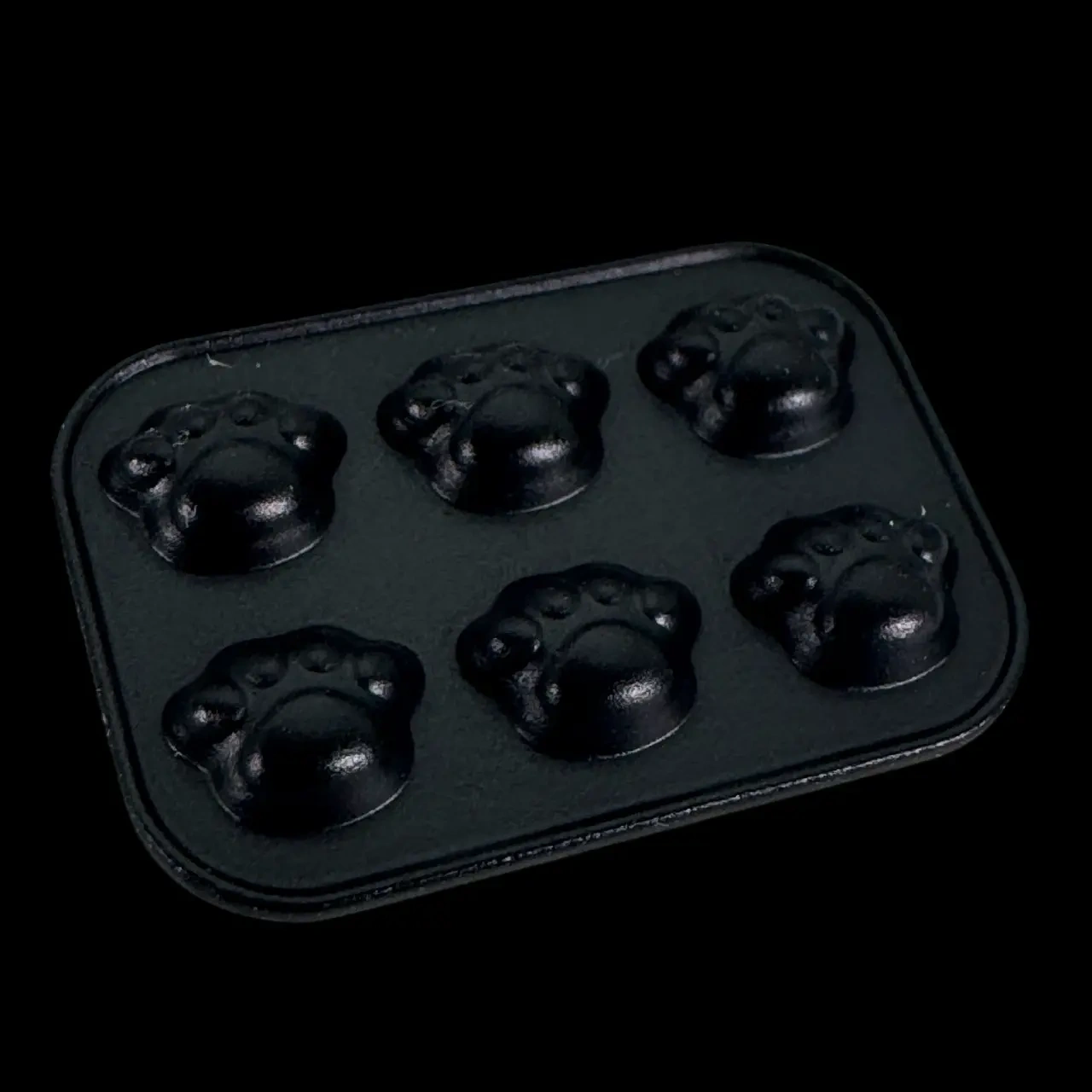 Moule miniature en métal noir avec six reliefs en forme de pattes d’ours