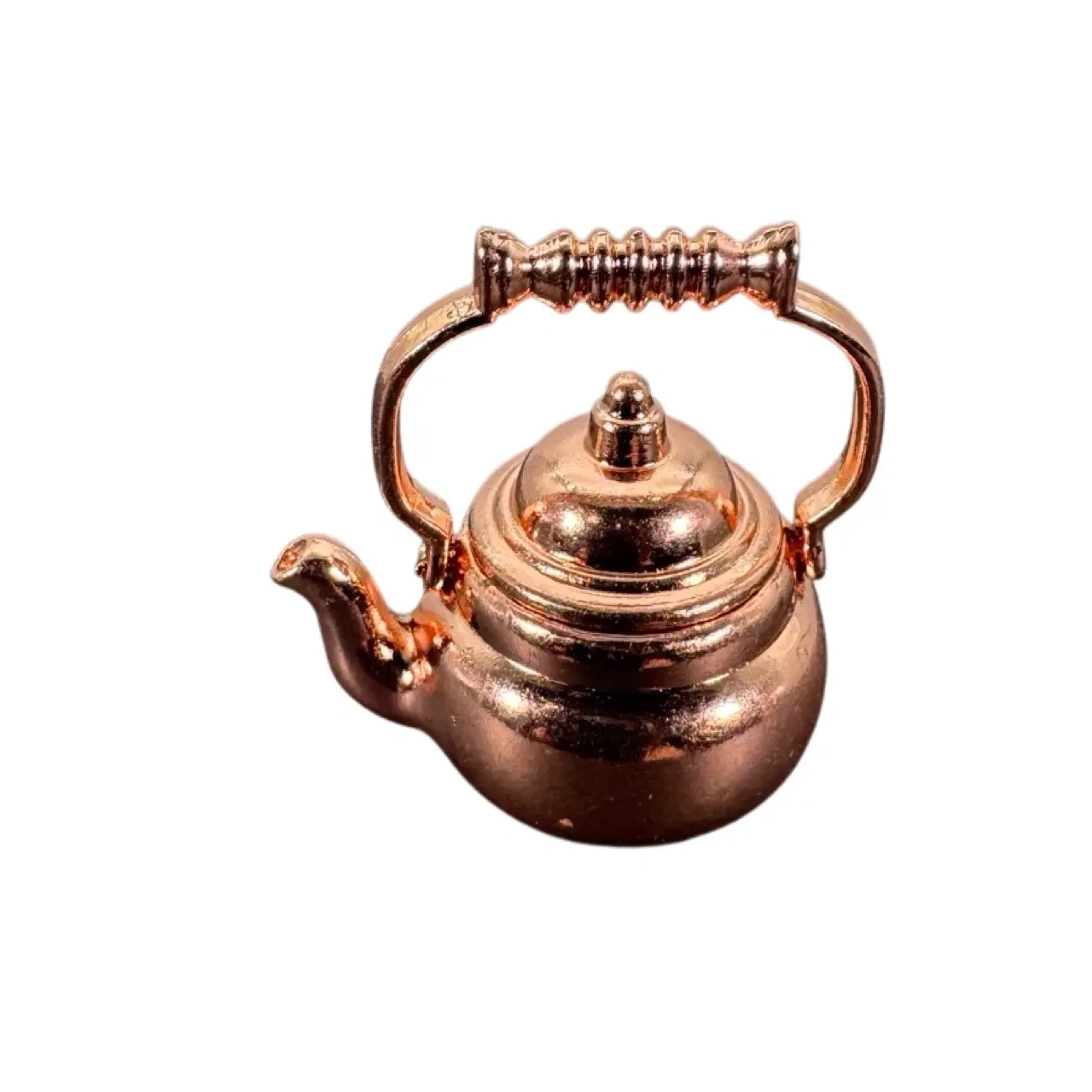 Bouilloire miniature cuivrée en métal sur fond blanc