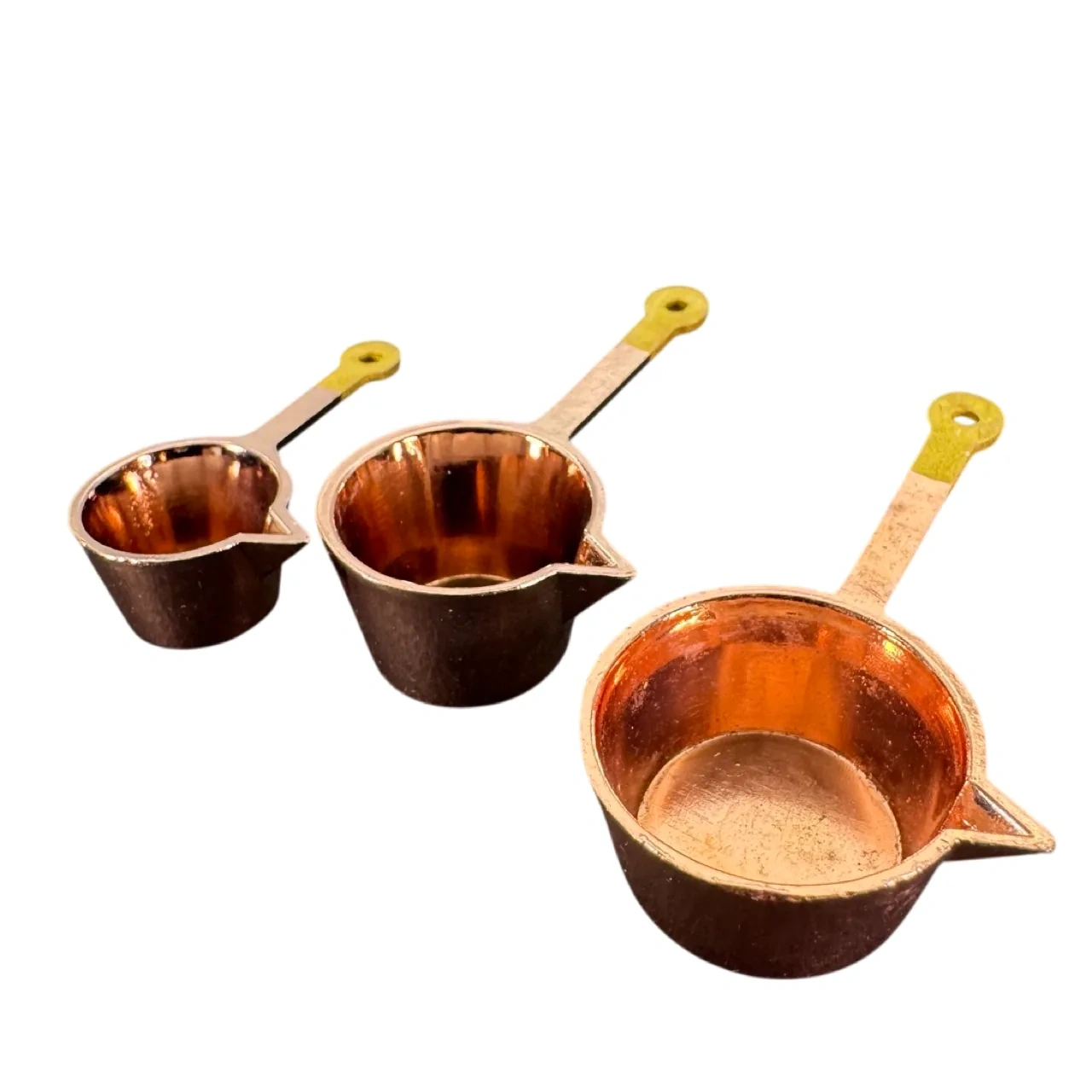 Lot de 3 casseroles miniatures cuivrées à manches jaunes sur fond blanc