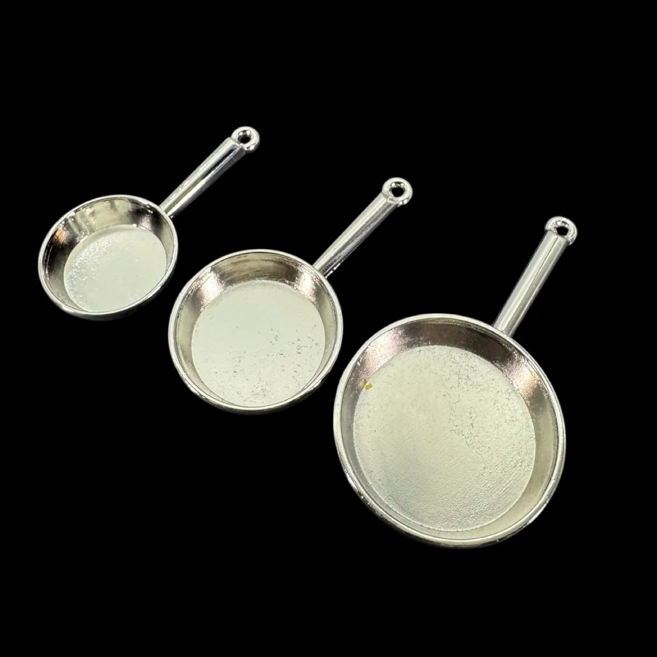 Lot de 3 poêles miniatures en métal coloris argent sur fond noir