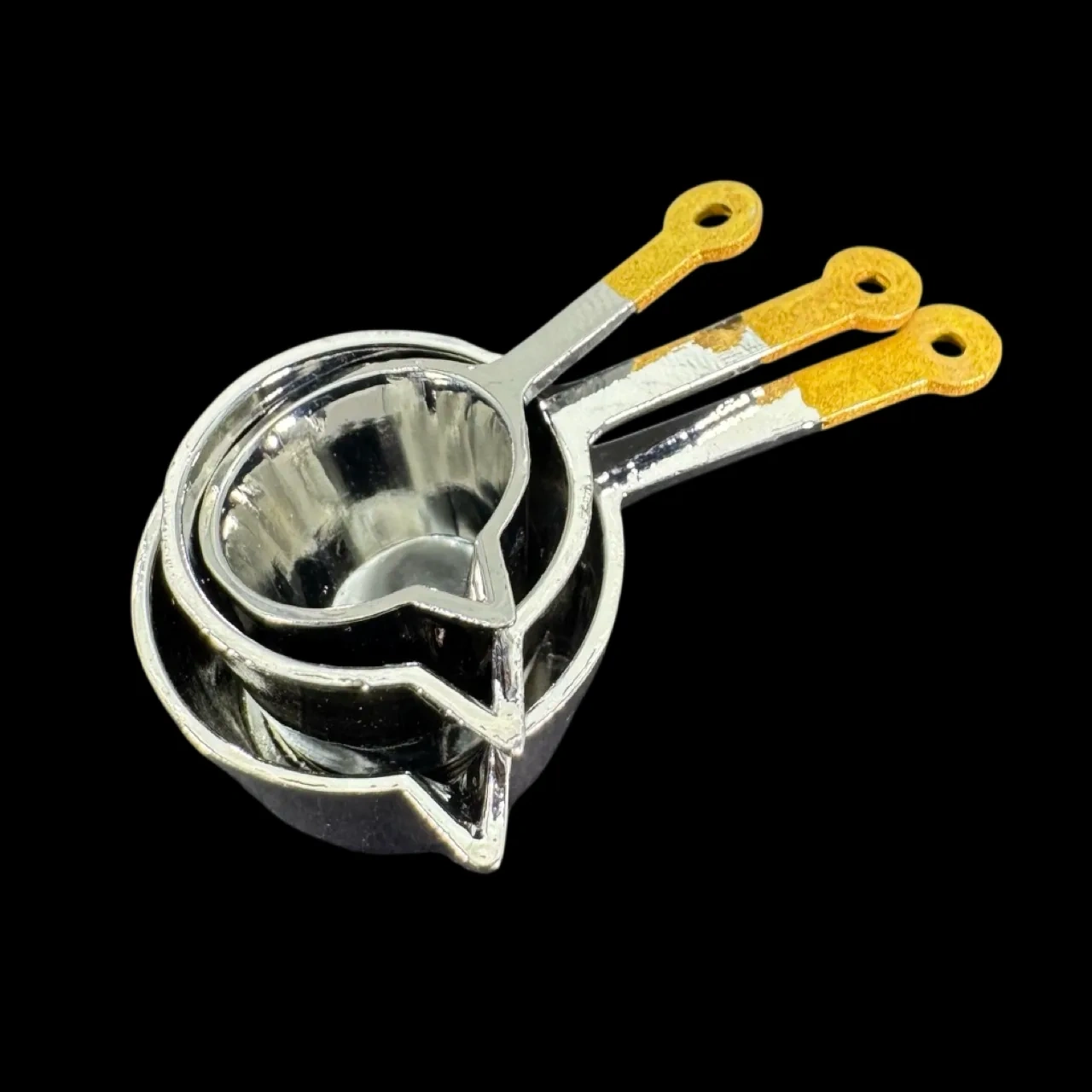 Lot de casseroles miniatures chromées manches jaunes sur fond noir